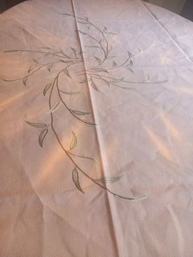 Mantel beige bordado a mano con puntilla marrón.