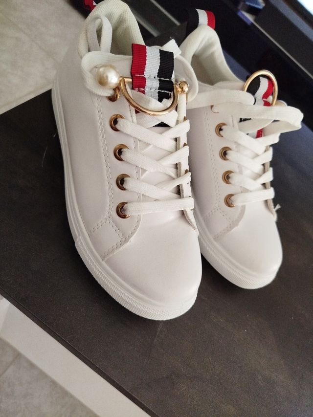 Zapatillas blancas con detalles dorados
