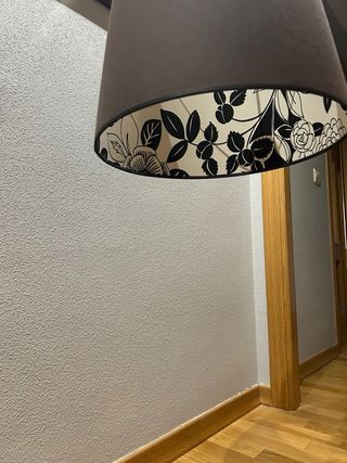 Lámpara colgante negra con flores en el interior.