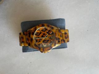 Reloj dorado con estampado marrón