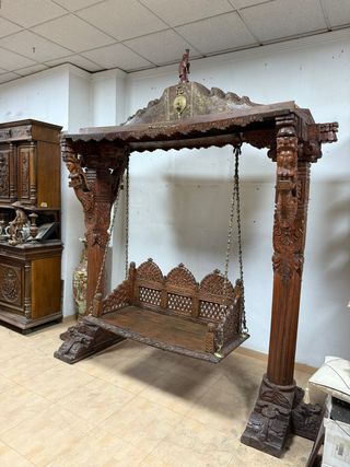 Gran columpio de madera con elaboradas tallas.