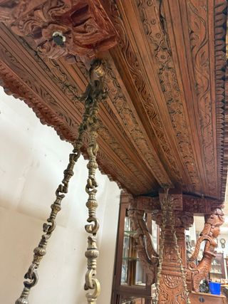 Gran columpio de madera con elaboradas tallas.