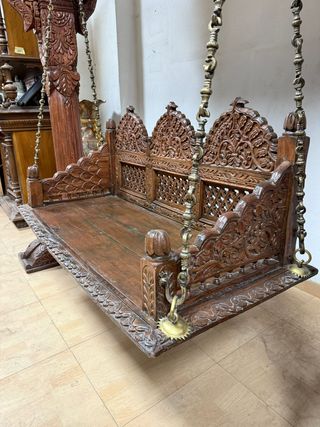 Gran columpio de madera con elaboradas tallas.