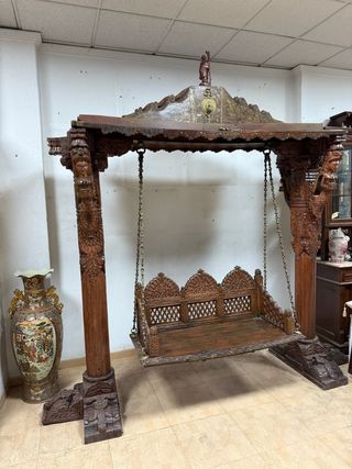 Gran columpio de madera con elaboradas tallas.
