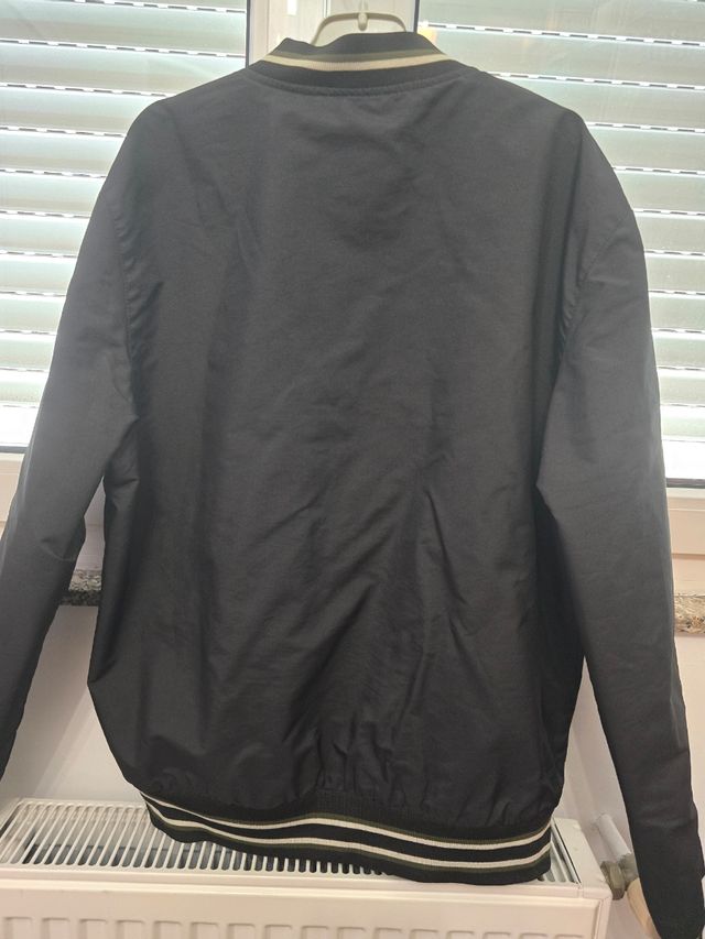 Cazadora universitaria negra.