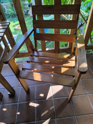 Banco de madera exterior, dos sillones y una mesa.