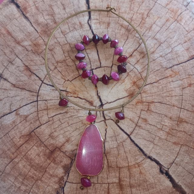 Collar y pulsera dorados con piedras rosas