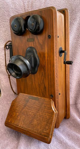 Teléfono antiguo de manivela montado en la pared