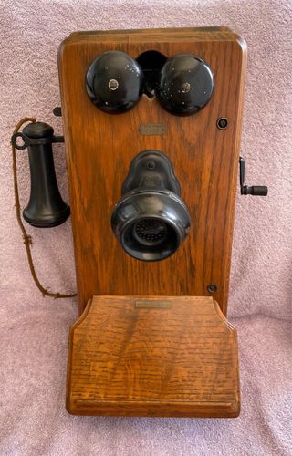 Teléfono antiguo de manivela montado en la pared