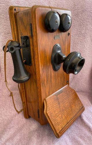 Teléfono antiguo de manivela montado en la pared