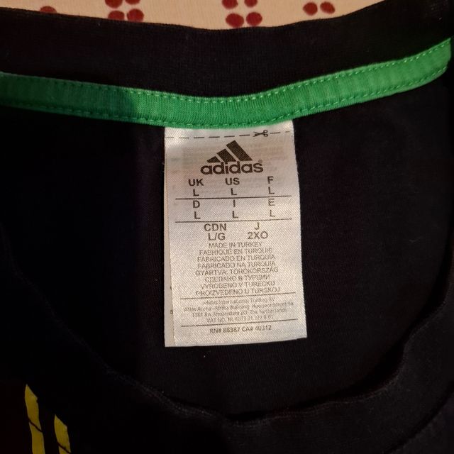 T-Shirt Adidas nera con stampa scarpe in giallo ve