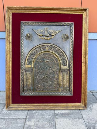 Porta del sagrario in bronzo incorniciata.