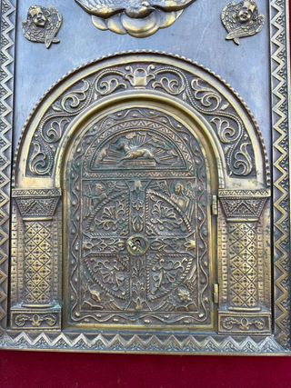 Porta del sagrario in bronzo incorniciata.