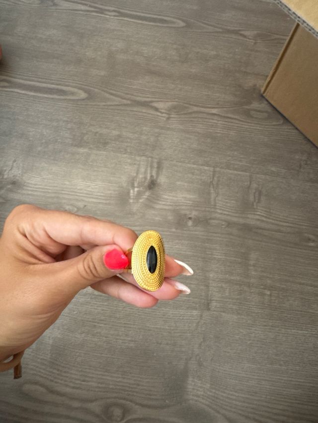 Anillo dorado con piedra negra