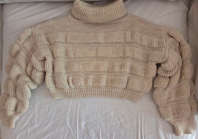 Suéter beige de punto, cuello alto y jersei rosa