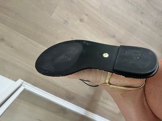 Sandalias doradas planas con la etiqueta.