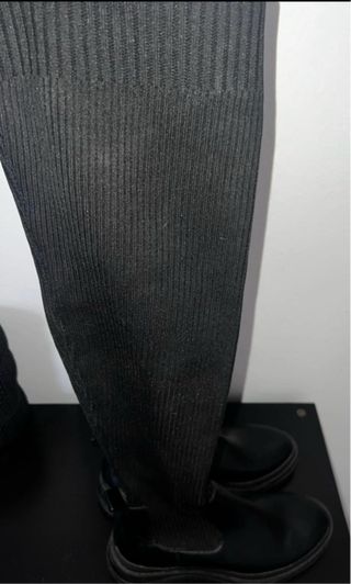 Botas negras altas, estilo calcetín.

