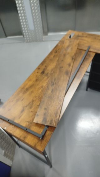 Escritorio esquinero marrón con cajonera