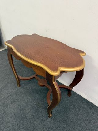 Bellissimo tavolino con forme e bordi dorati.