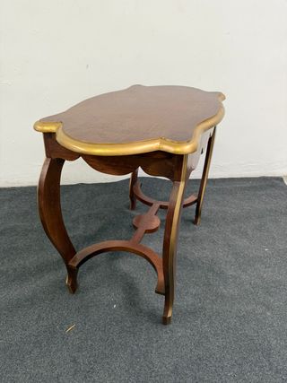 Bellissimo tavolino con forme e bordi dorati.