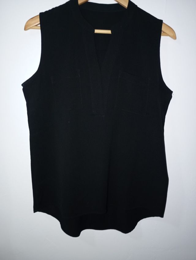 Blusa negra sin mangas, un poco más larga por atrá