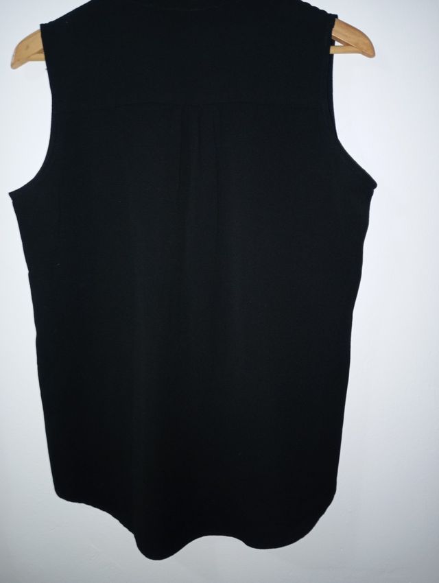 Blusa negra sin mangas, un poco más larga por atrá