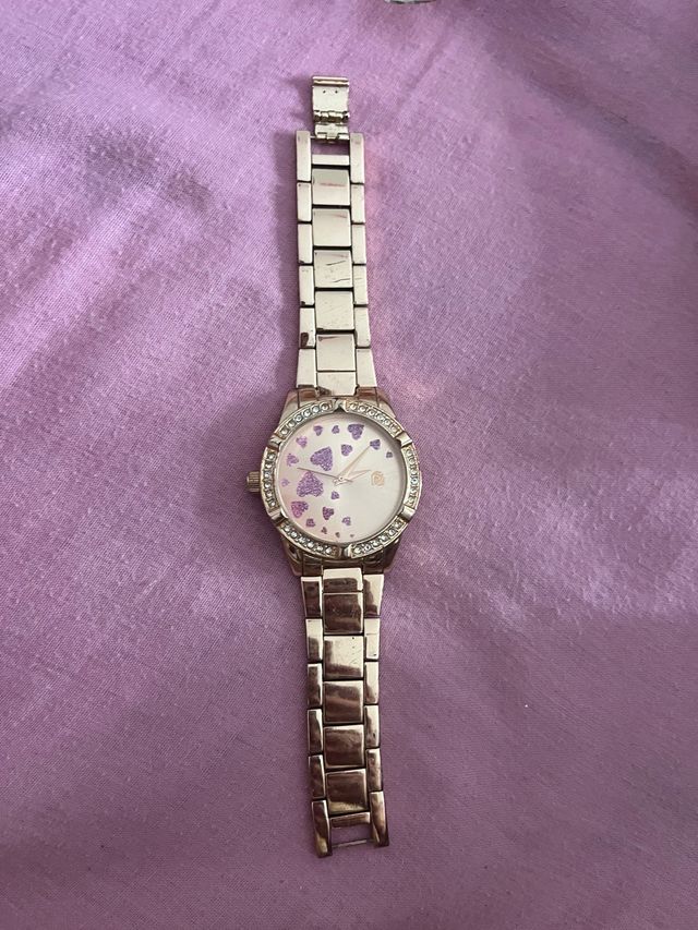 Reloj dorado con corazones rosa