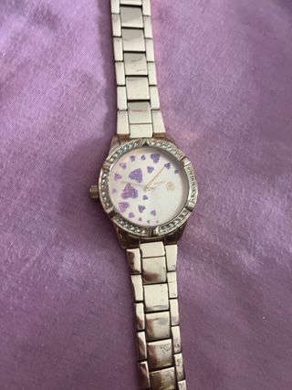 Reloj dorado con corazones rosa