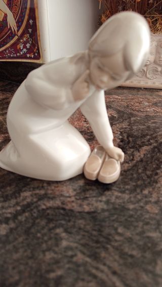 Figura de LLADRO, niña recogiendo zapatillas.