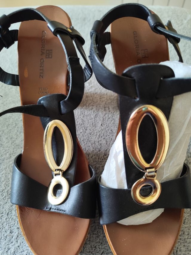 Sandalias Gloria Ortiz negras doradas.