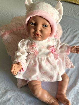 Muñeca bebé con cojín rosa