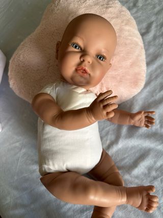 Muñeca bebé con cojín rosa