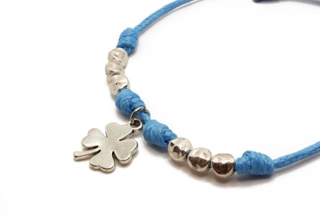 Pulsera de hilo azul con colgante de trébol