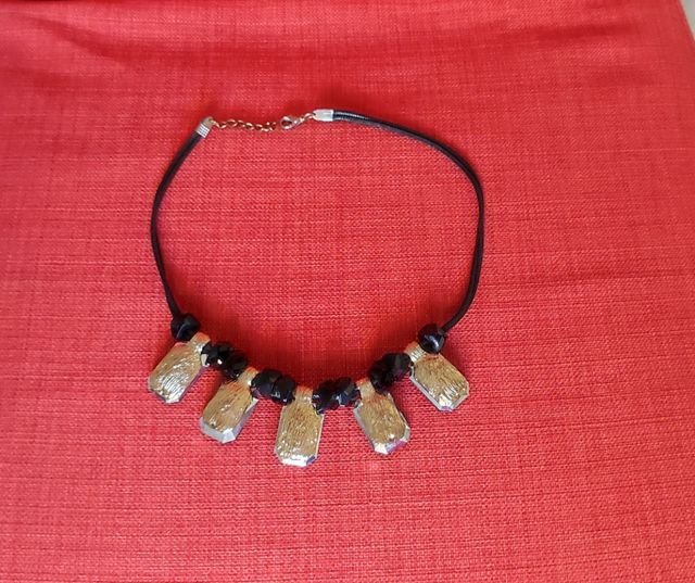 Collana con ciondoli neri e dorati.