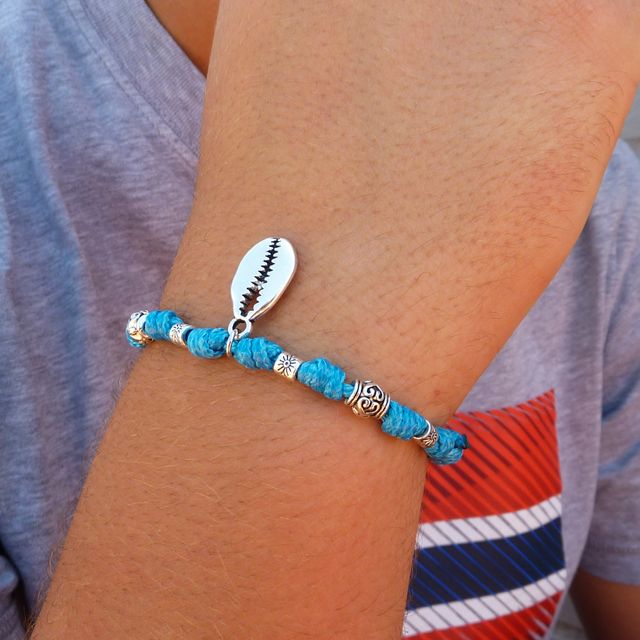 Pulsera azul con nudos de la suerte y concha caurí