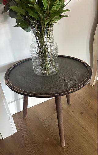 Mesa auxiliar redonda madera oscura.
