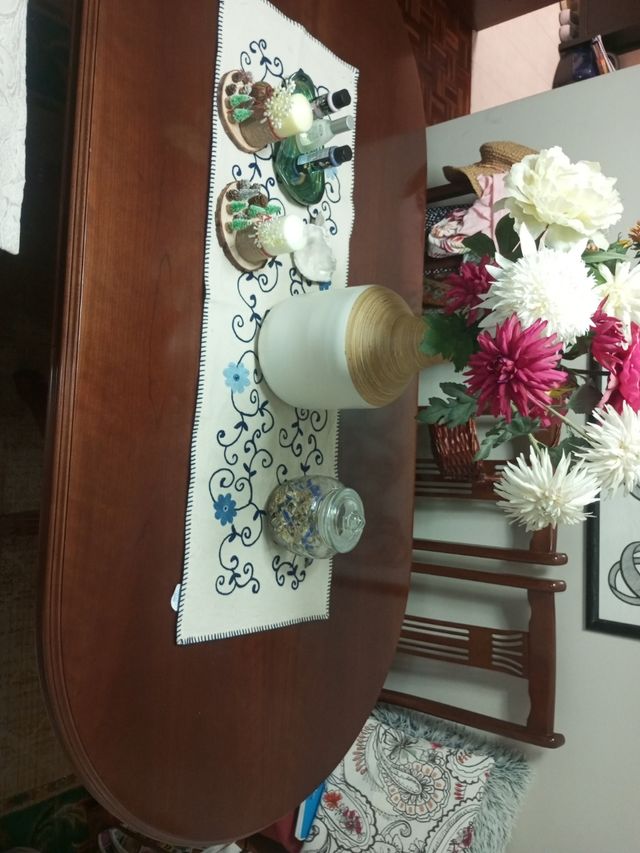 Mesa comedor ovalada madera con cuatro sillas.