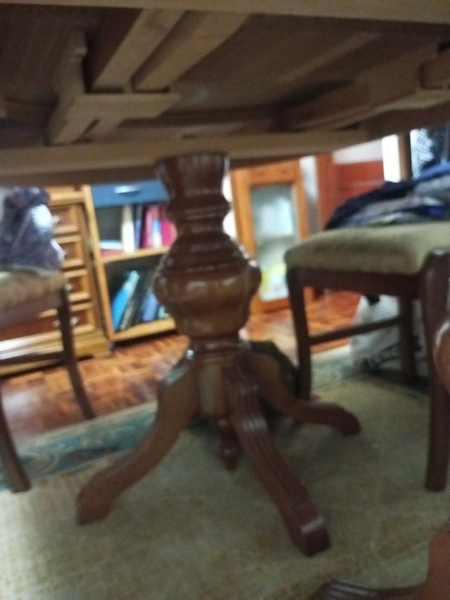 Mesa comedor ovalada madera con cuatro sillas.