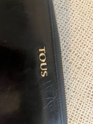 Cartera Tous con cremallera color negro.