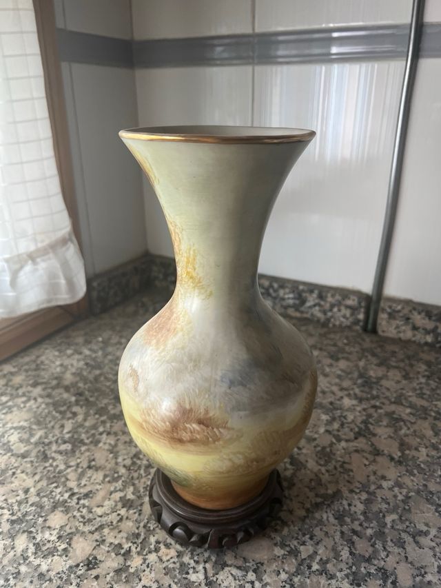 Jarrón antiguo con soporte de madera