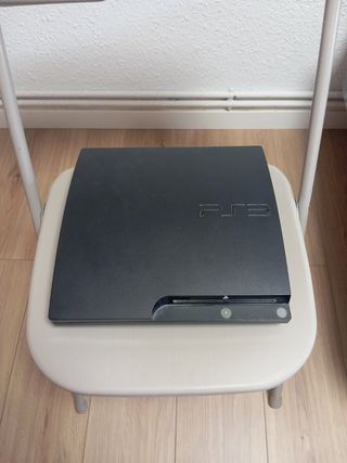 PS3 (PlayStation 3) negra con juegos y un mando