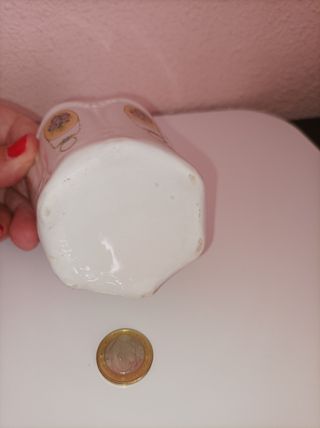 Maceta o vaso de cerámica blanca con adornos.