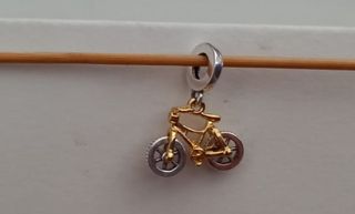 Charm colgante Bicicleta dorada y plateada.
