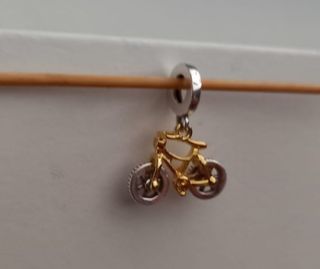 Charm colgante Bicicleta dorada y plateada.