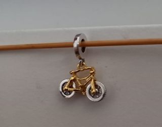 Charm colgante Bicicleta dorada y plateada.