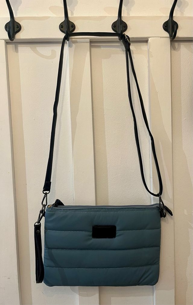 Bolso bandolera o tipo clutch azul acolchado.