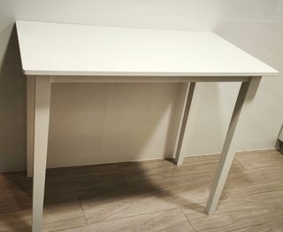 Mesa blanca alta de madera aglomerada.