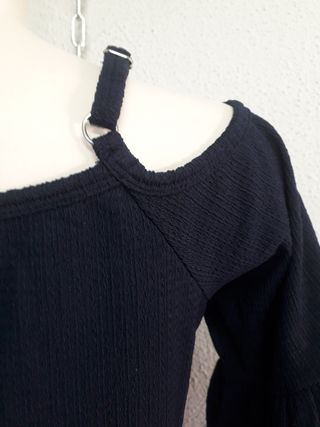 Blusa azul marino con hombros descubiertos.