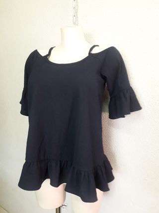 Blusa azul marino con hombros descubiertos.