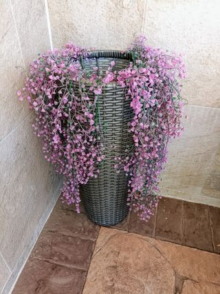 Maceta mimbre gris con flores rosa